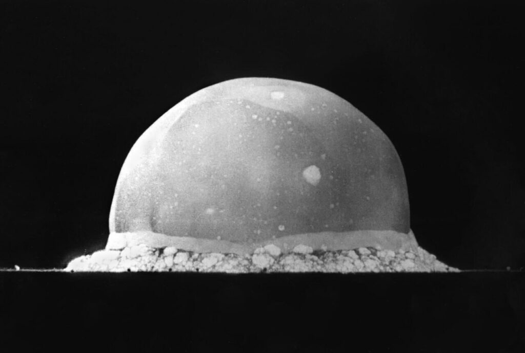 Fotografia in bianco e nero della prima esplosione nucleare con la sfera di fuoco
